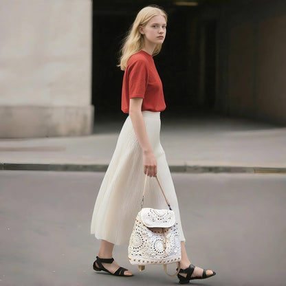Eiyye Crochet Backpack carried by hand while walking on the street, showcasing its handmade cotton rope texture and unique boho style
