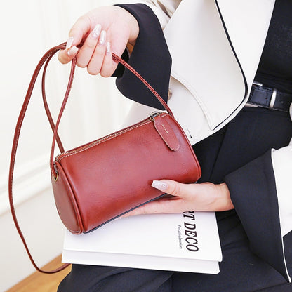 Coffee Leather Crossbody Bag carried by hand with a graceful shape and timeless leather style for daily occasions